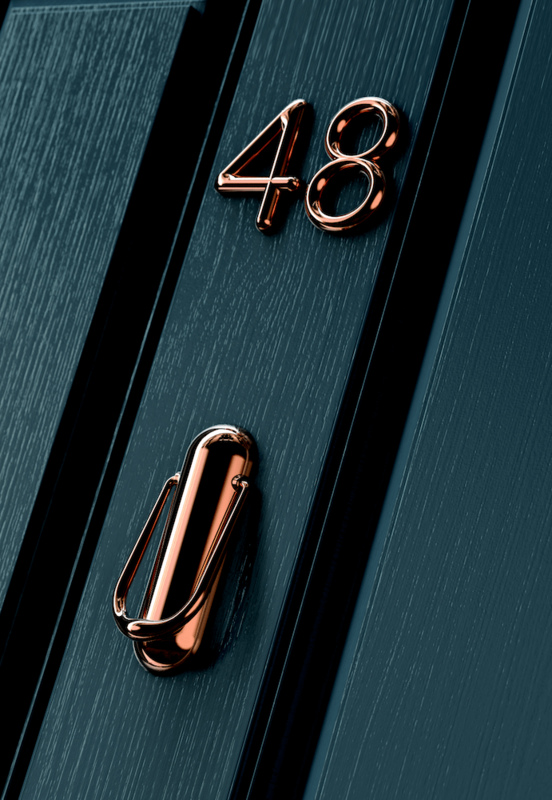 Black door with copper numbers and knocker